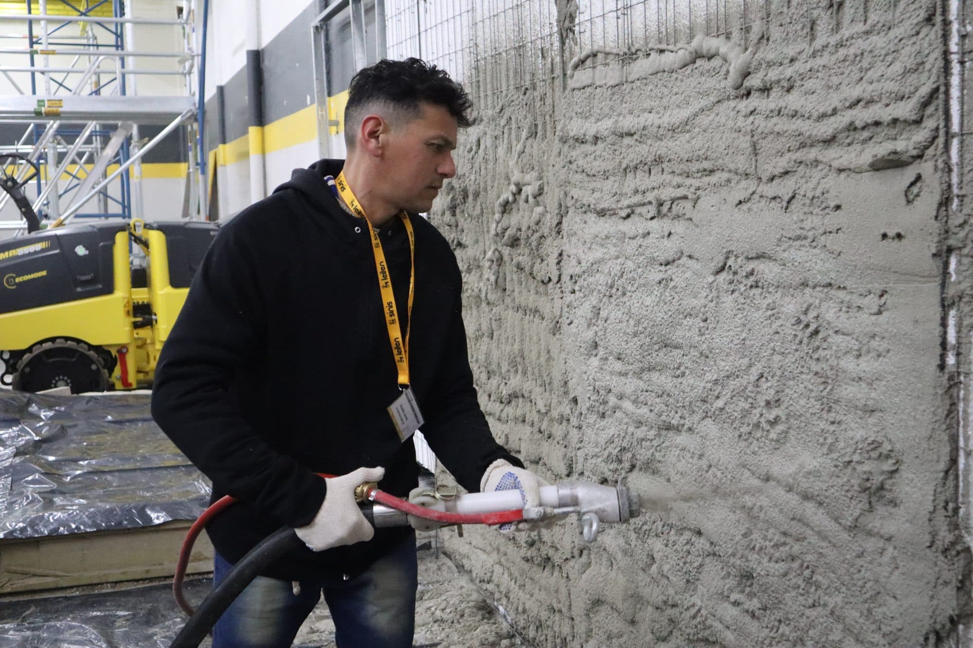 Operario proyectando revoque cementicio con máquina Leiten